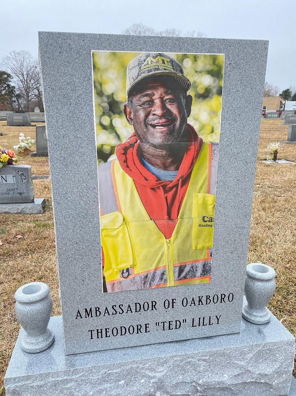 Three kiln‑fired porcelain tiles forming a full‑color mural of Ted Lilly, mounted on his granite headstone at Oakboro City Cemetery