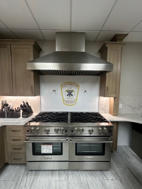 Eastchester EMS custom printed porcelain tile mural backsplash with kiln-fired porcelain logo detail