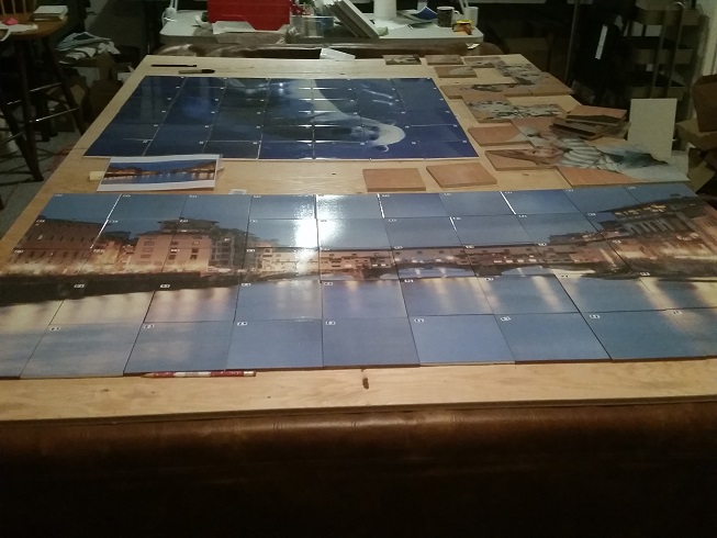 Waterfront buildings and polar bear tile murals laid out together on a PicturedTile workshop table.