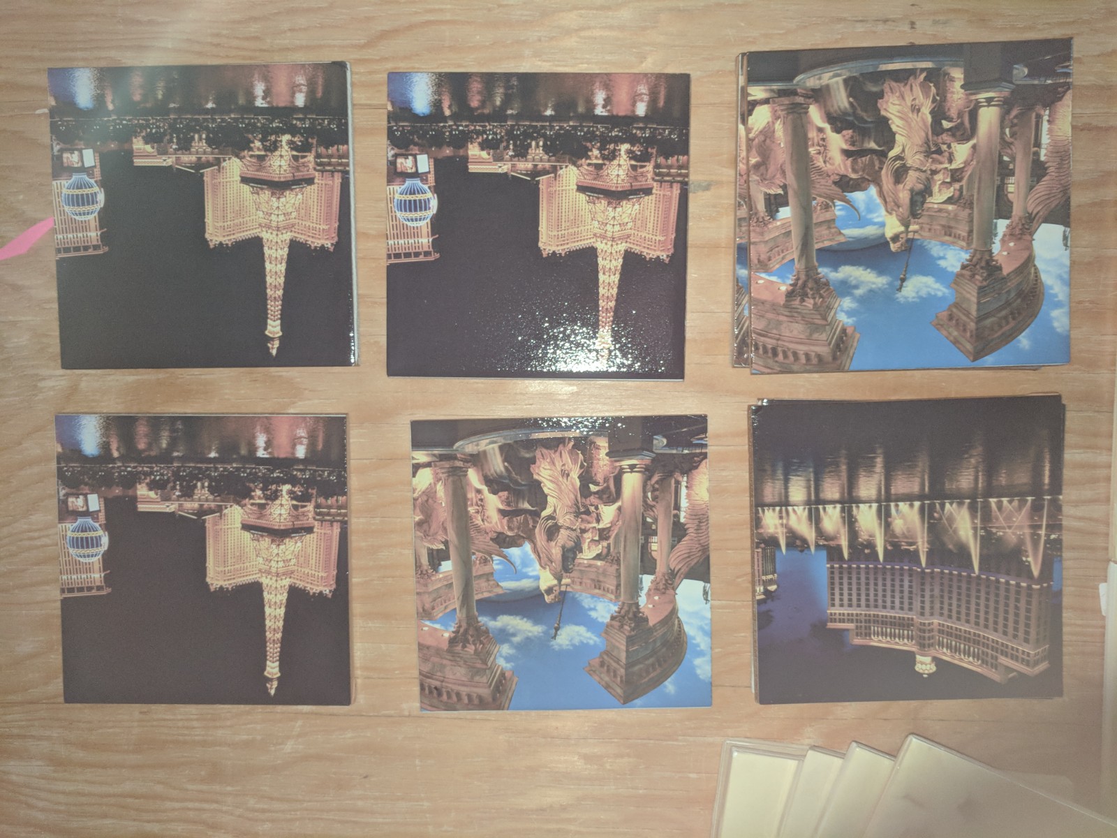 Six square floor tiles printed with Las Vegas landmarks and night scenes, arranged on a workshop table.